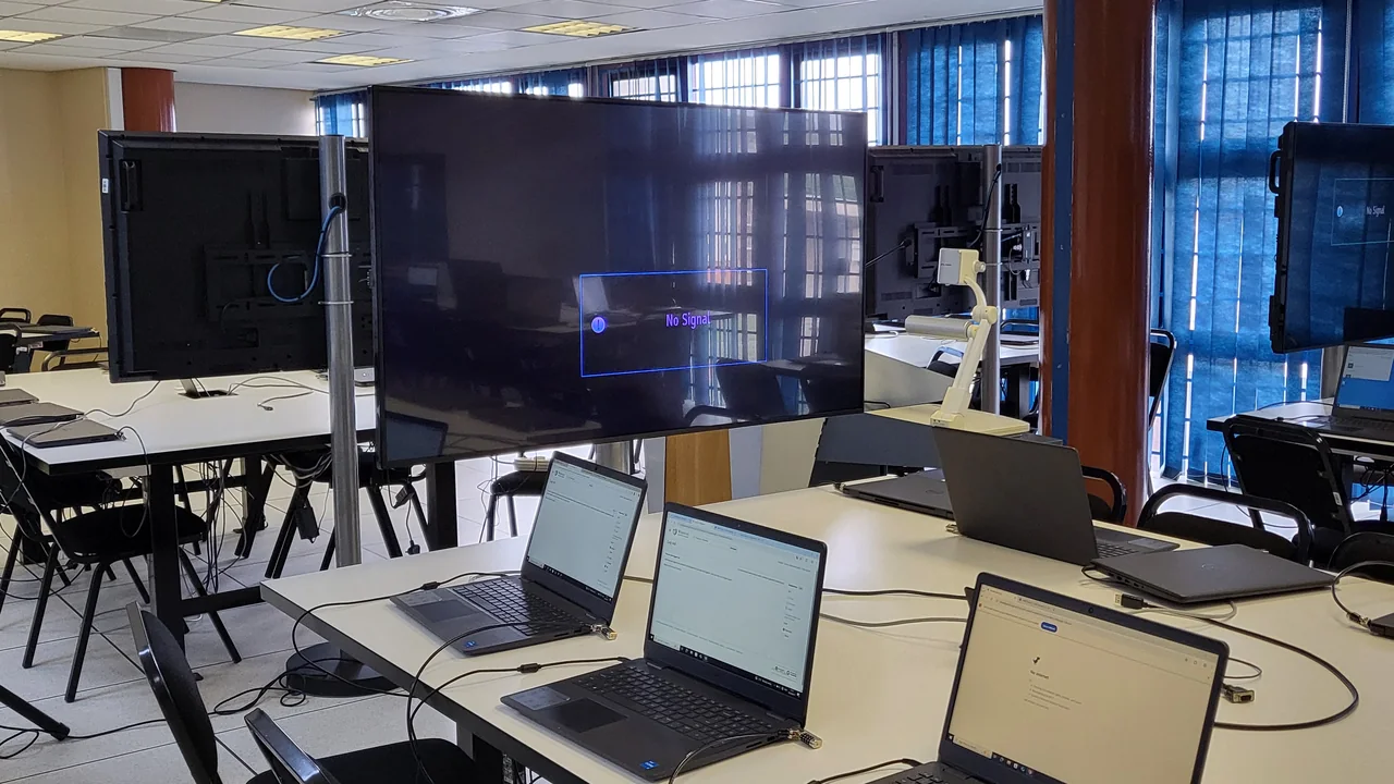 Sala de aula com computadores e telas usada como exemplo de ambiente para formulário digital de diagnóstico