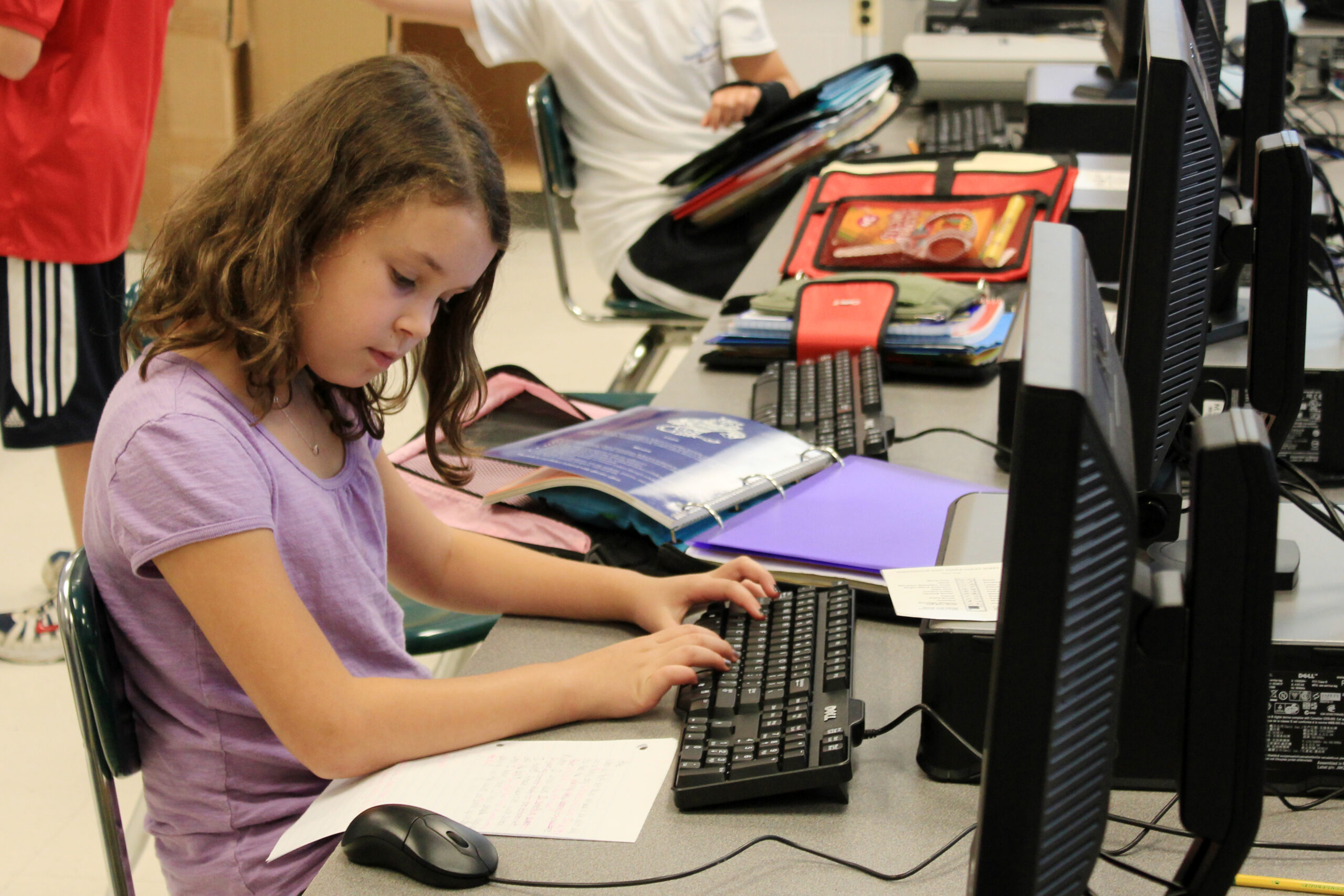 Estudante realiza uma atividade em computador em uma escola