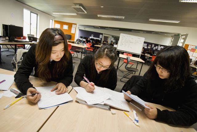 Estudantes revisando conteúdo juntos em uma sala de aula