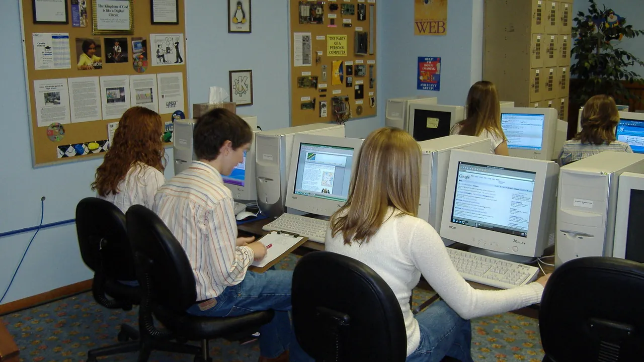 Estudantes trabalhando em computadores em um laboratório escolar