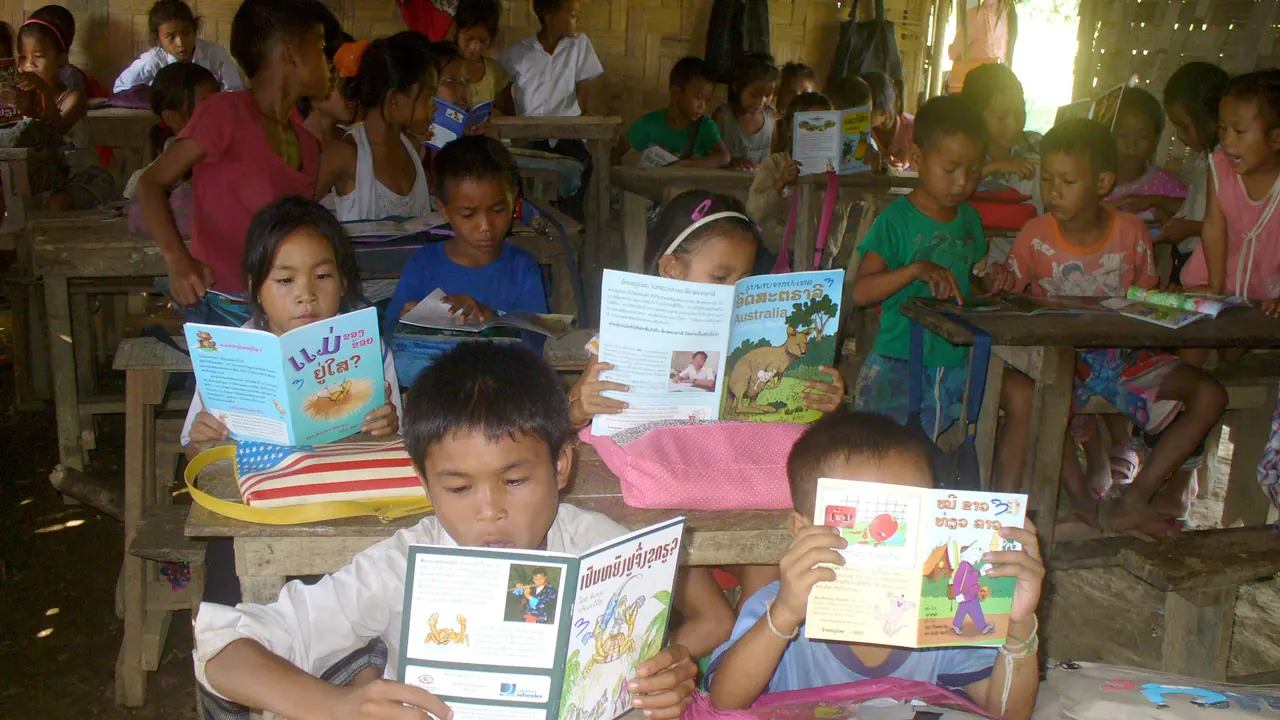 Estudantes leem livros durante uma atividade de leitura em uma escola