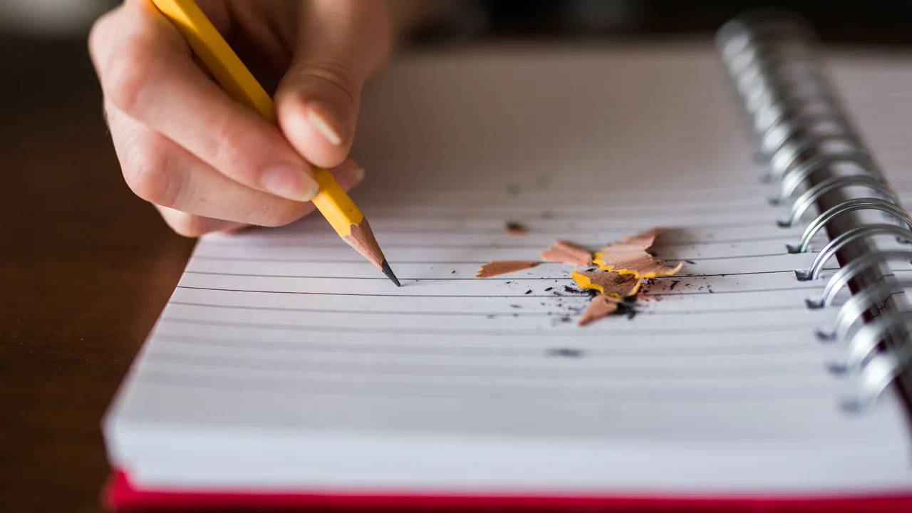 Pessoa fazendo anotações em um caderno durante o estudo