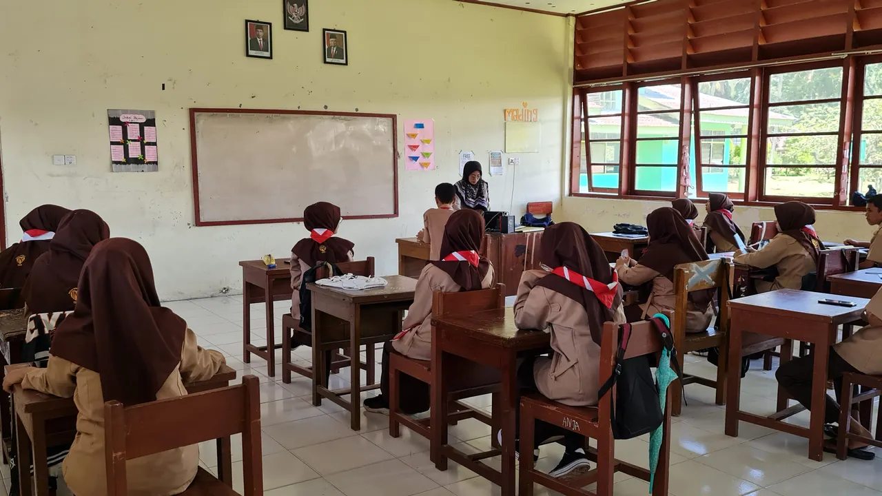 Sala de aula com professora e estudantes realizando uma atividade