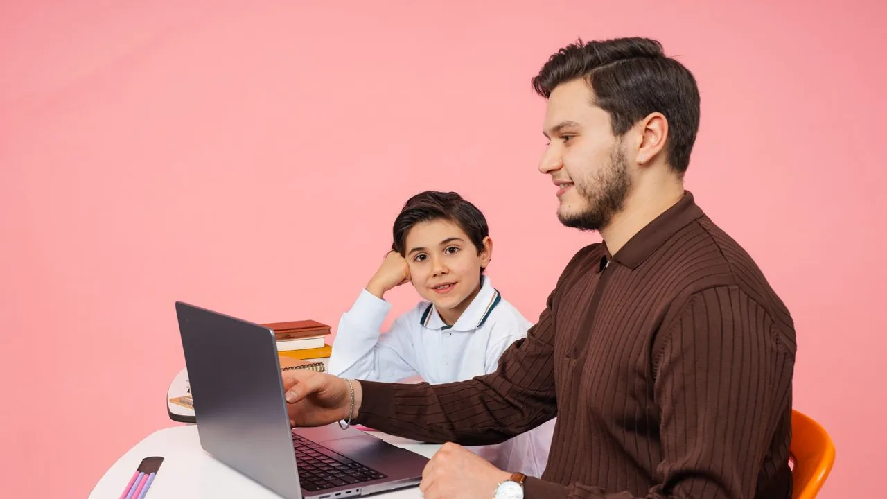 Professor orientando estudante diante de um laptop durante uma atividade