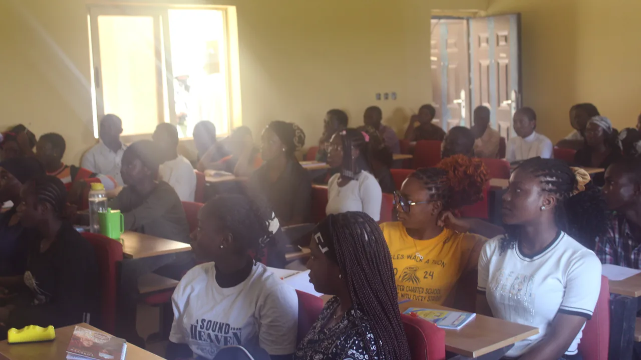 Professor conversa com estudantes que registram observações durante uma aula