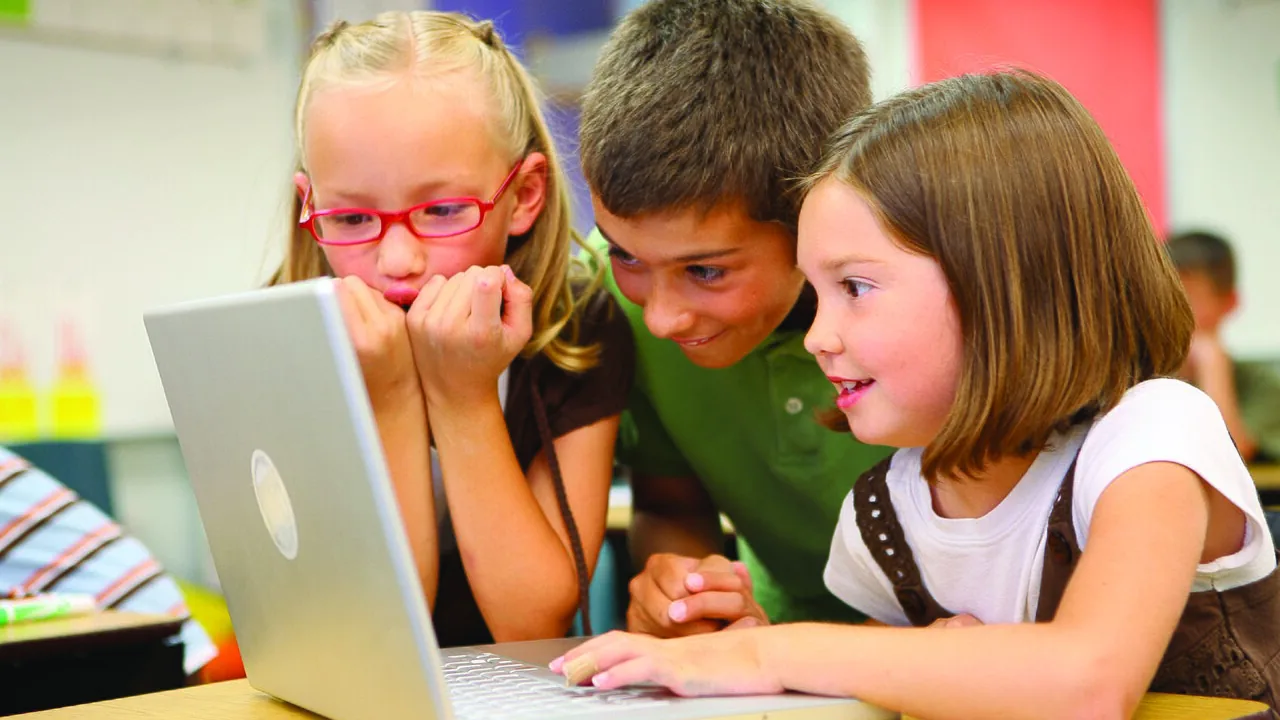 Estudantes trabalhando juntos em uma atividade escolar com computador