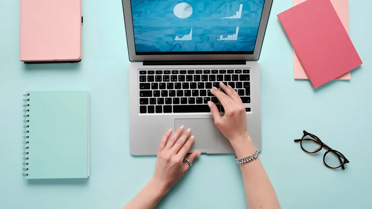 Mãos usando um notebook que exibe gráficos e dados