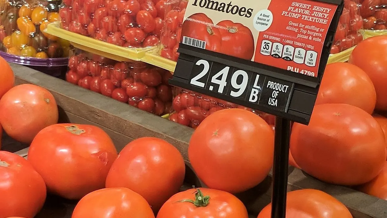 Placa de preço de tomates em uma seção de supermercado